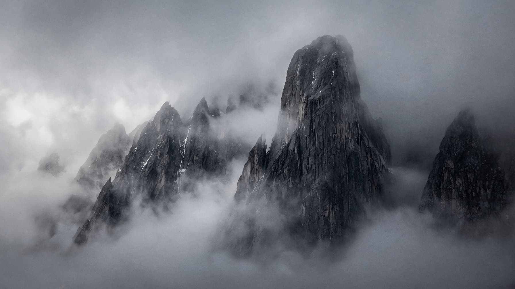 Granite peaks emerging through dense fog.